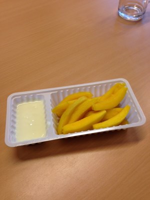 Patatjes gemaakt van mango met een dipsausje van yoghurt.